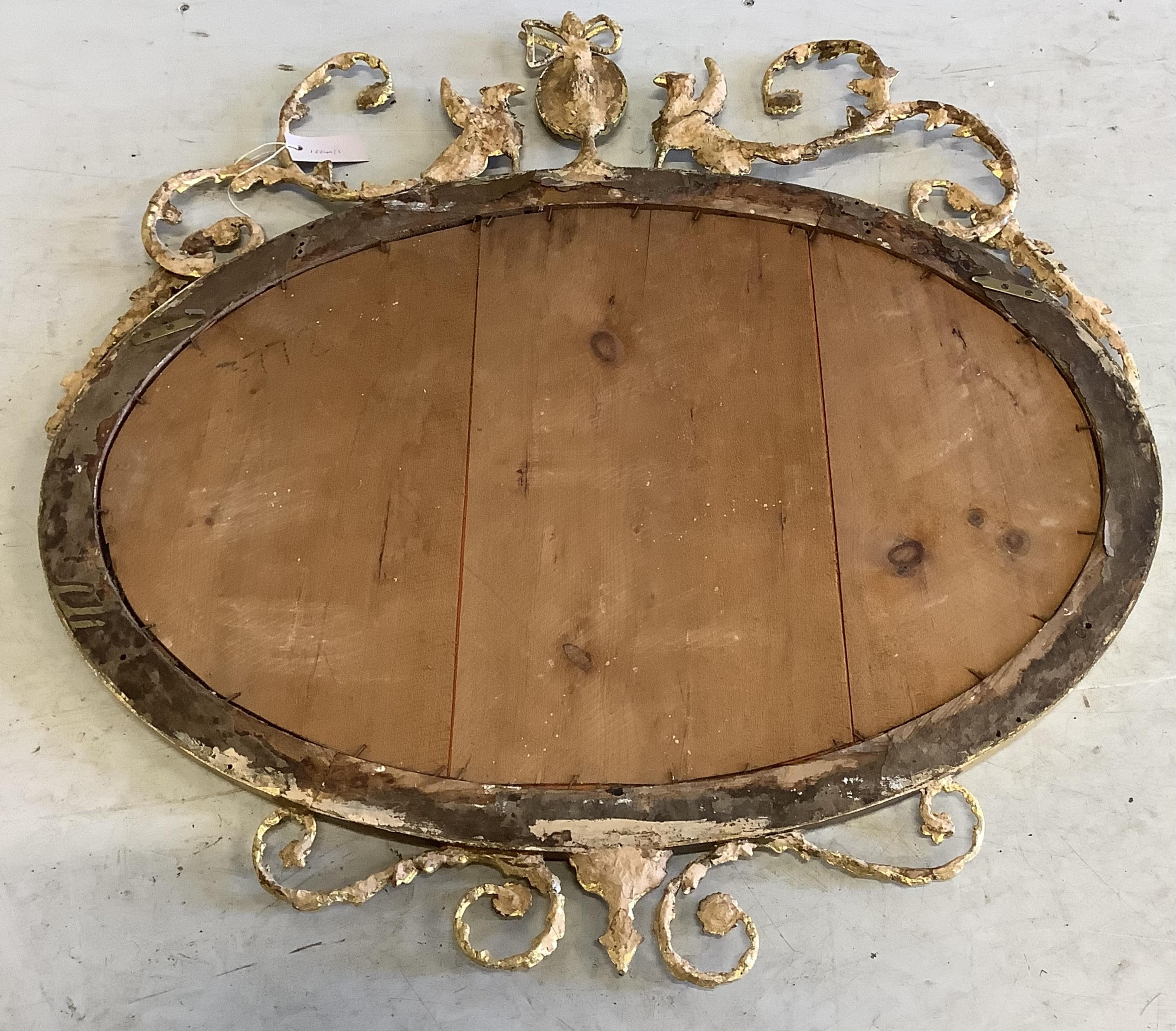 An Edwardian Sheraton Revival oval giltwood and composition wall mirror, width 86cm, height 90cm. Condition - fair